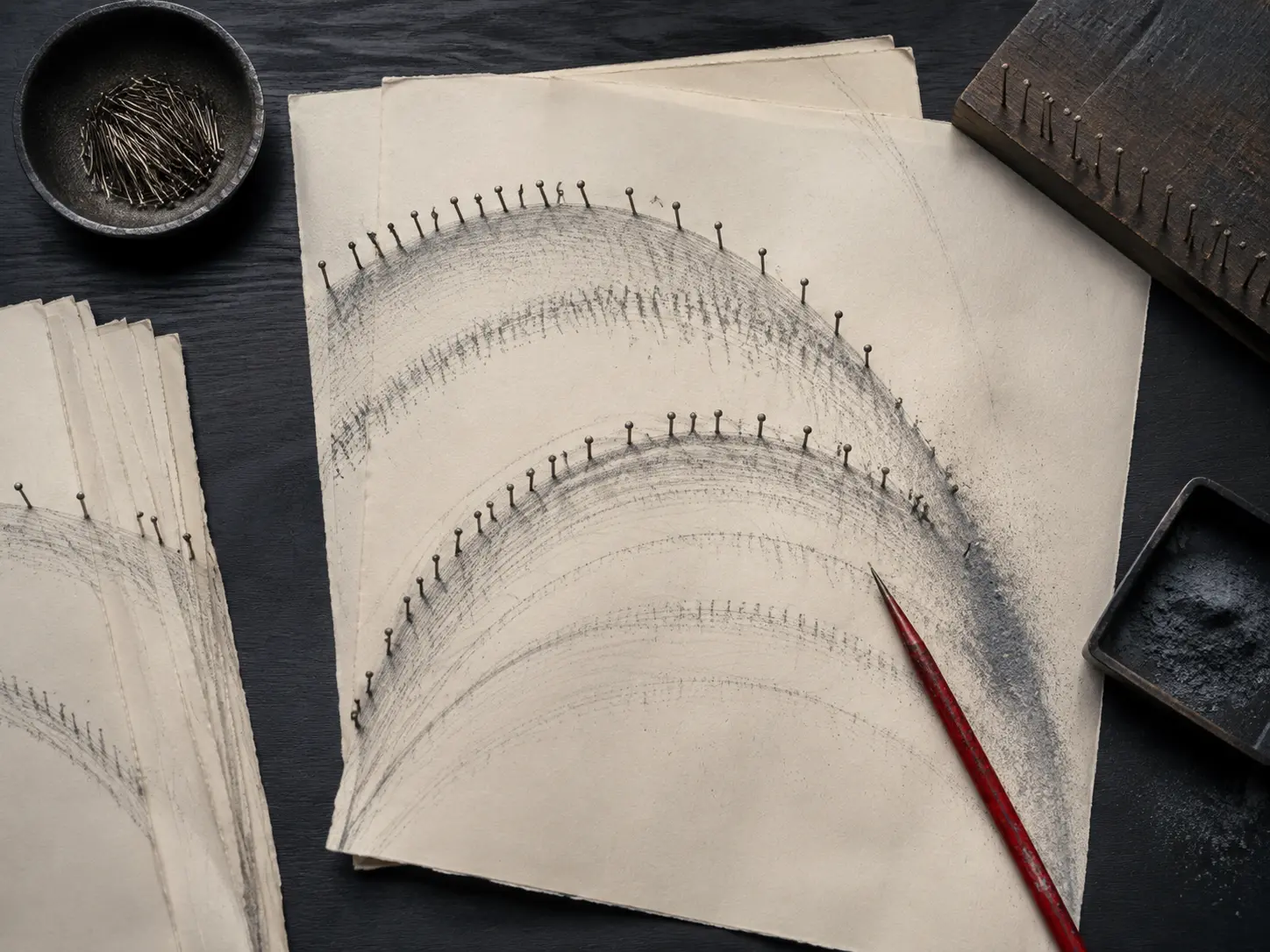Ivory motion-study papers marked by graphite arcs and steel timing pins on blackened oak